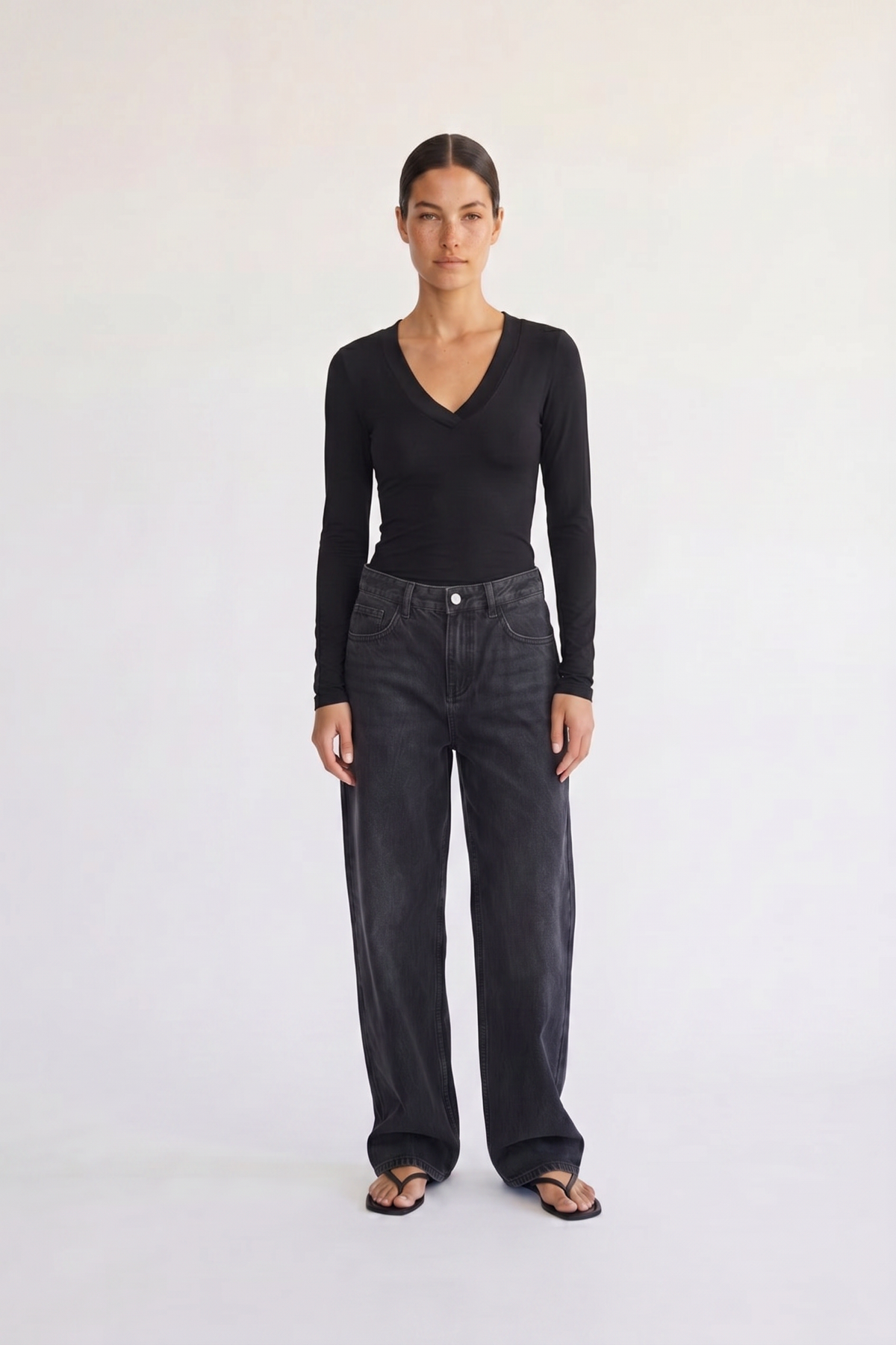 Woman wearing the Margaux black deep V henley top, front view