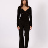 Woman wearing the Noa black lace long sleeve top, front view